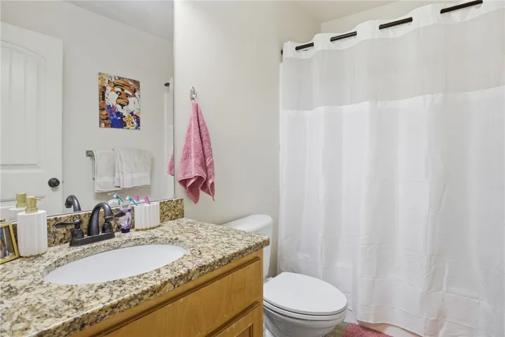 This bathroom features a contemporary vanity with a granite countertop.