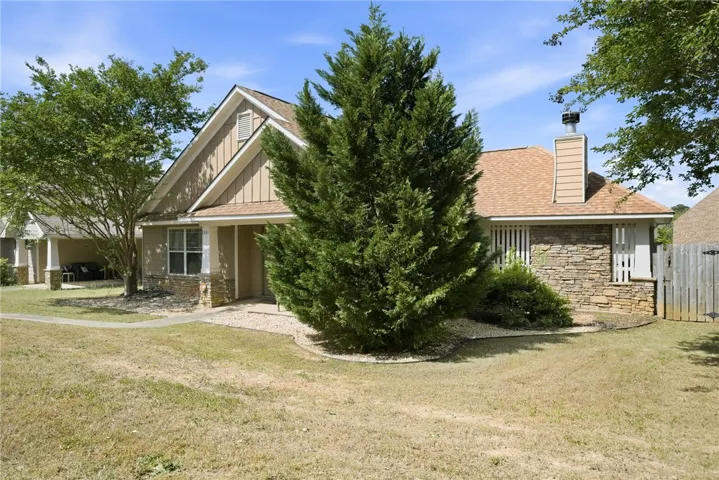 This charming home features a lovely facade with mixed materials, creating a welcoming curb appeal.