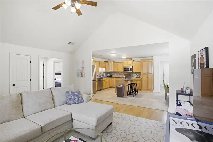 This inviting space features an open-concept design, connecting the living area to a well-appointed kitchen.