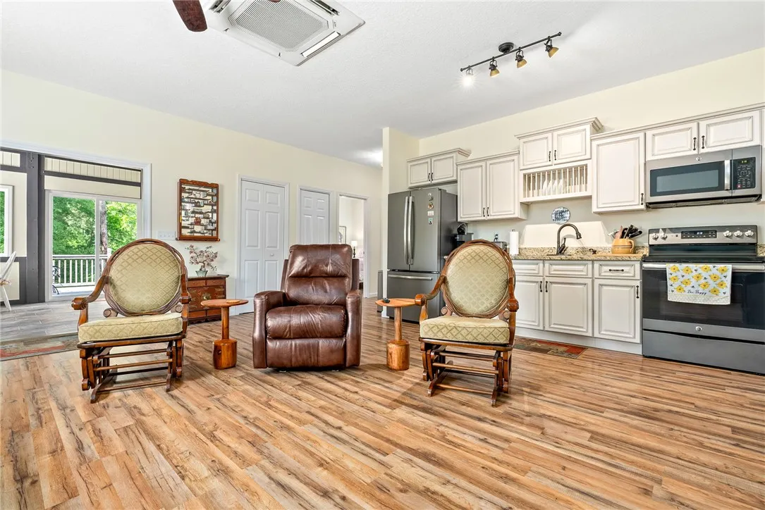 This inviting space combines a cozy living area with a functional kitchen, featuring durable flooring.
