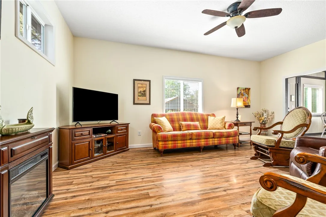 This inviting living room boasts wood flooring and ample natural light, creating a comfortable ambiance.