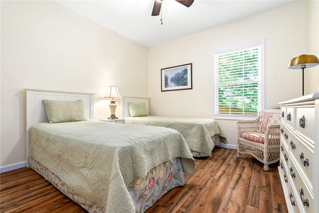 This inviting bedroom features rich hardwood flooring and a ceiling fan for comfort.