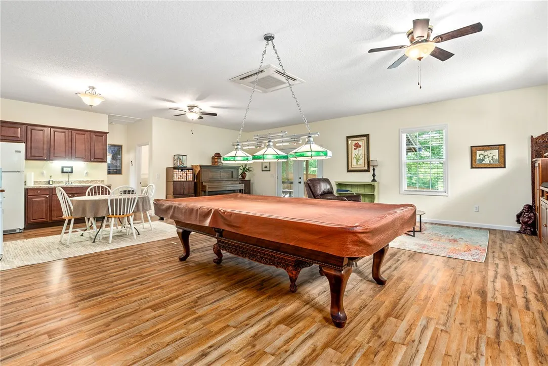 An inviting open-concept living space features warm wood-look flooring and ample natural light.