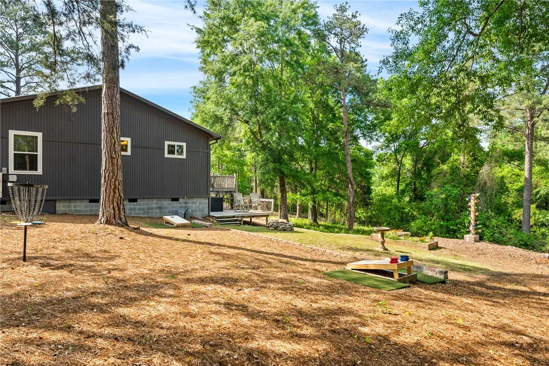 This private yard features a spacious deck and ample space for outdoor activities, surrounded by lush trees.