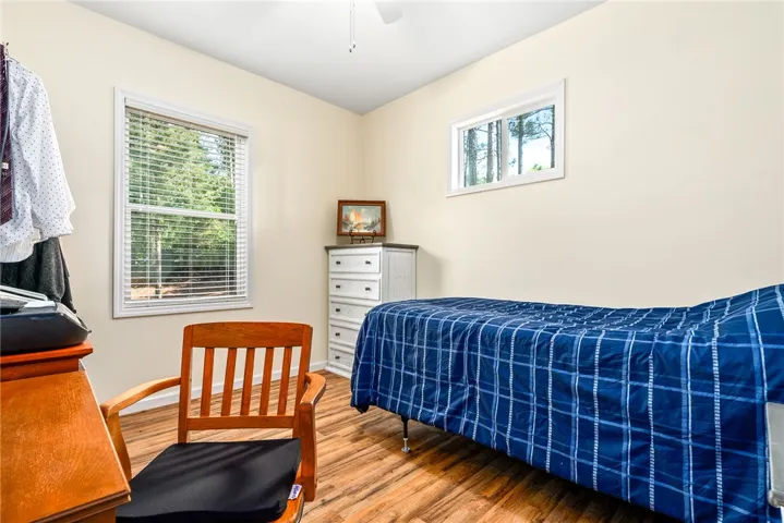 This cozy bedroom features durable wood flooring and ample natural light.