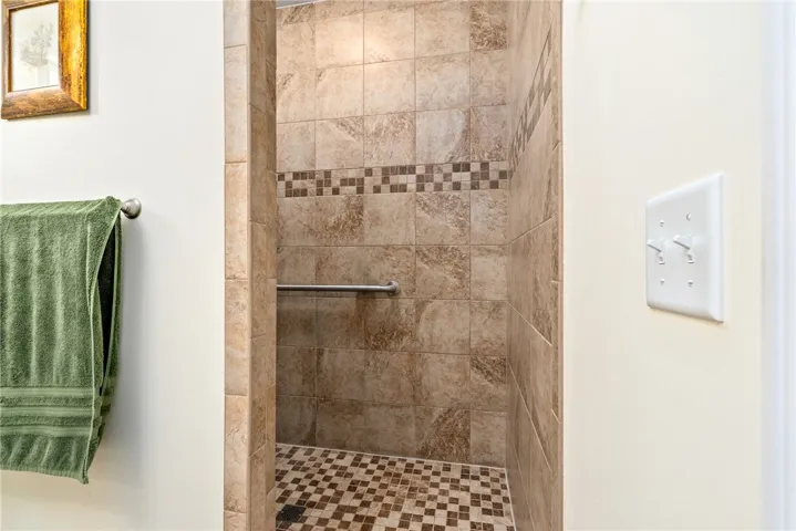 This shower features an accessible design with tasteful tile work, offering both style and convenience.