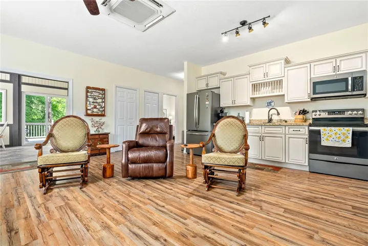 This inviting space combines a cozy living area with a functional kitchen, featuring durable flooring.