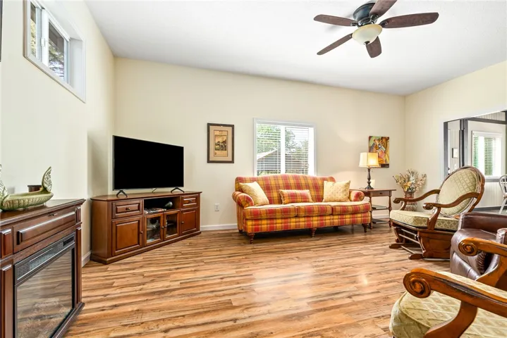 This inviting living room boasts wood flooring and ample natural light, creating a comfortable ambiance.