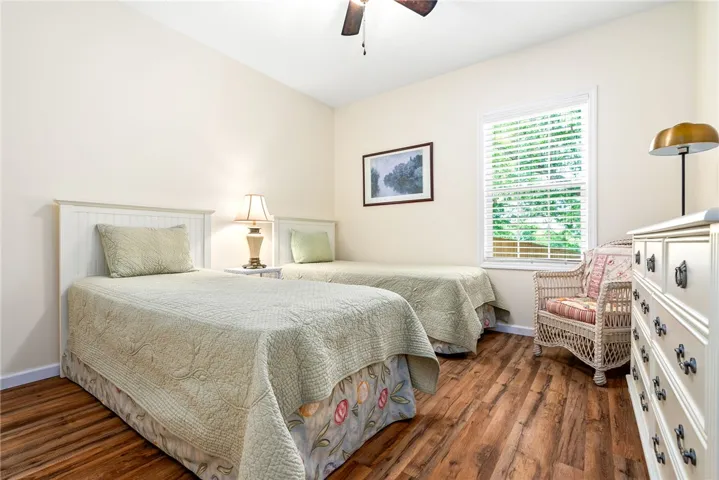 This inviting bedroom features rich hardwood flooring and a ceiling fan for comfort.