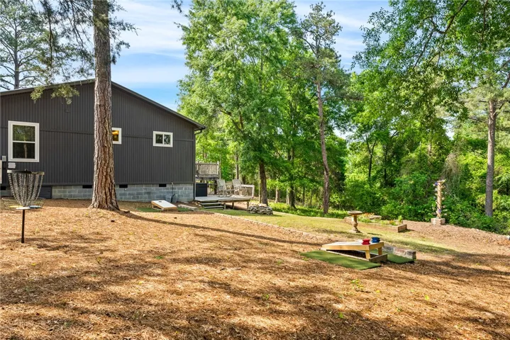 This private yard features a spacious deck and ample space for outdoor activities, surrounded by lush trees.