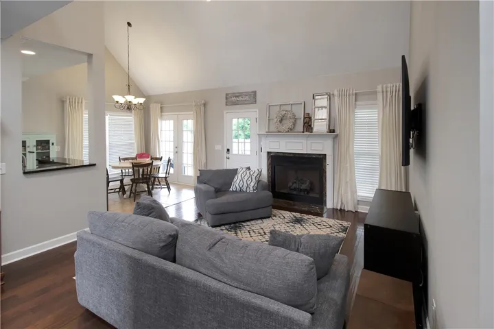 This inviting living space features high ceilings and a cozy fireplace, perfect for gatherings.