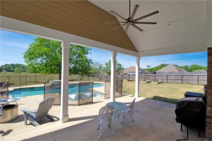 This inviting patio offers a seamless transition to the refreshing pool and private yard.