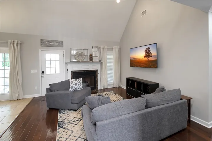 This bright living room features high ceilings and a cozy fireplace, perfect for gatherings.