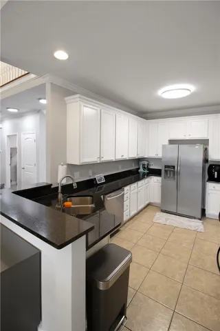 This contemporary kitchen features elegant countertops and a full suite of modern appliances.