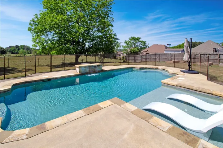 This tranquil outdoor oasis features a refreshing pool, perfect for relaxation or recreation.