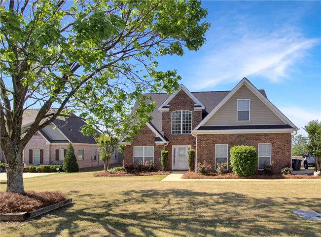 This classic brick residence features a lush lawn, providing a welcoming curb appeal.