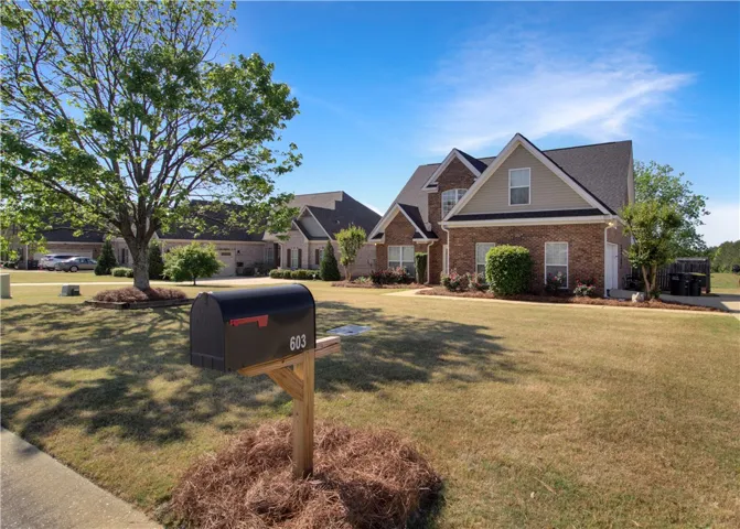 This charming residence features a classic brick exterior and a well-maintained front yard.