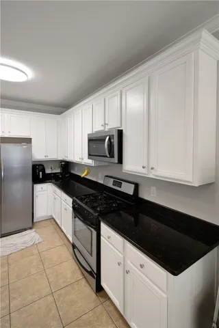 This modern kitchen features pristine white cabinetry and sleek granite countertops, creating a bright and inviting culinary space.