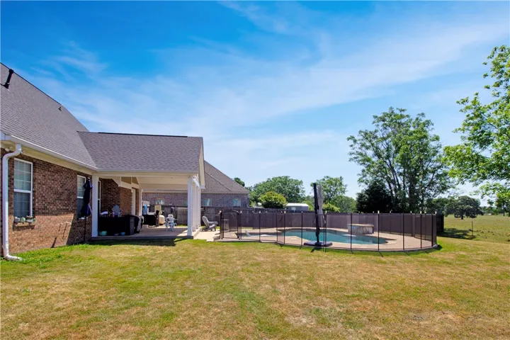 Enjoy outdoor living with a spacious covered patio, private pool, and expansive yard.