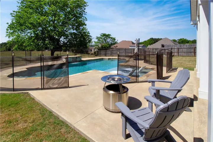 This spacious backyard oasis features a fenced pool and ample patio space for relaxation.