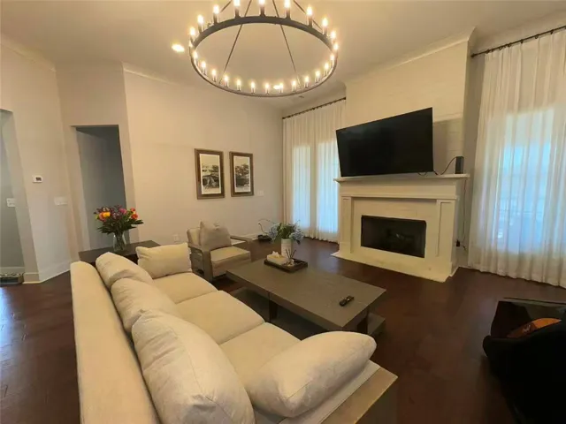 This living area features a warm fireplace, rich hardwood floors, and abundant natural light.