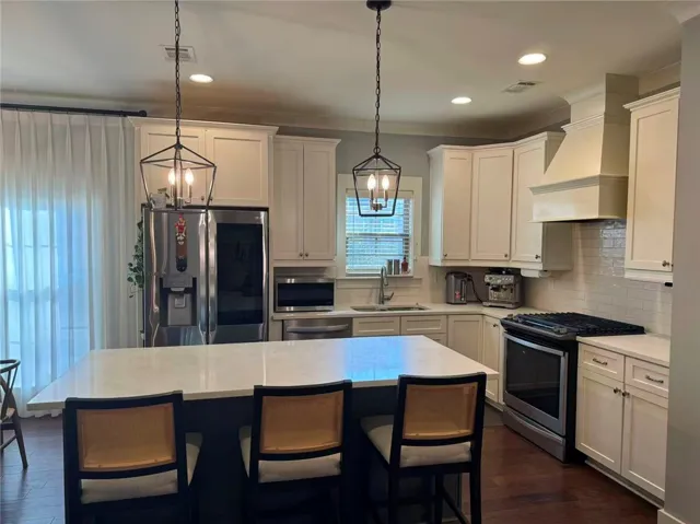 This modern kitchen features a spacious island and sleek stainless steel appliances.
