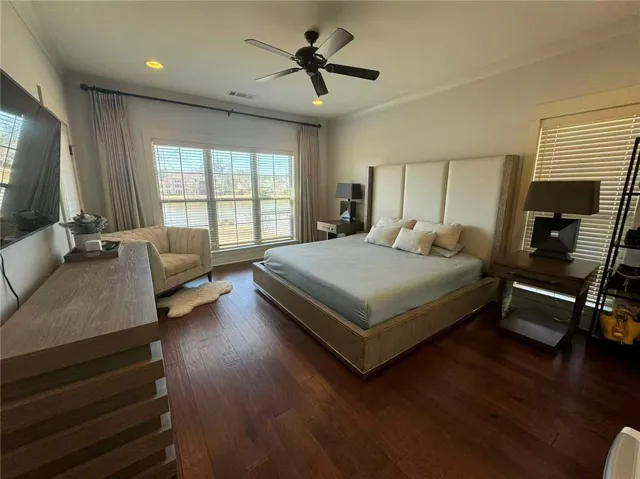 This spacious primary bedroom offers ample natural light and a serene view of the outdoors.