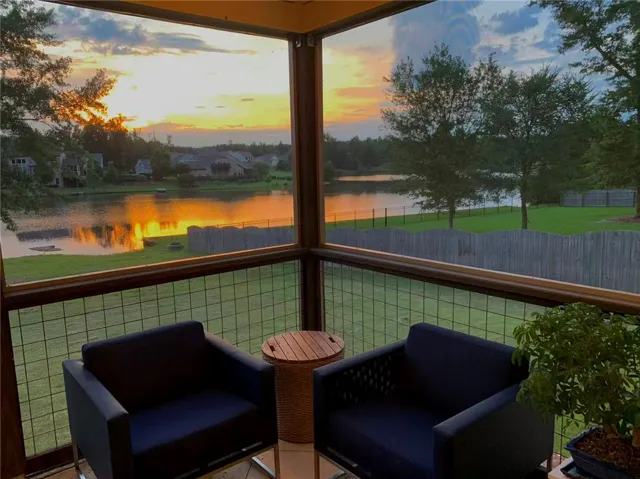 Enjoy tranquil lake views from this screened-in patio, perfect for evening relaxation.