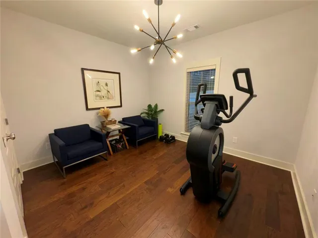 This versatile room features warm wood flooring, offering both comfort and functionality.