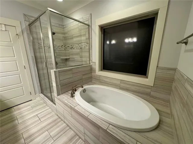 This serene bathroom offers a spacious walk-in shower and a built-in soaking tub, perfect for relaxation.