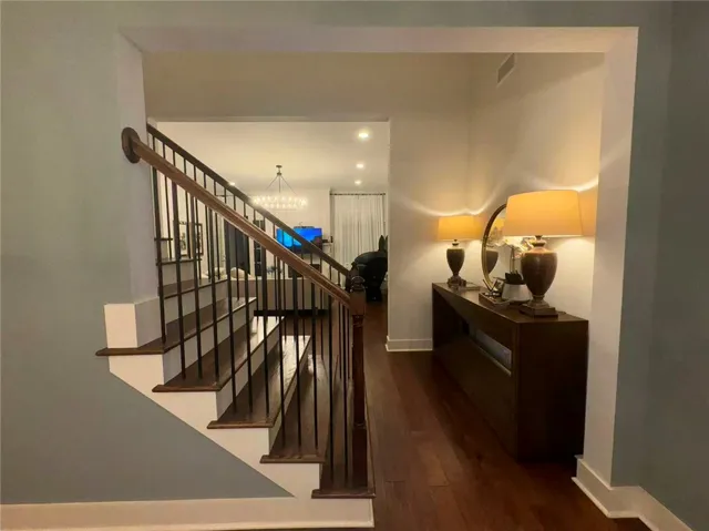 This inviting entrance features rich hardwood flooring and a classic staircase.