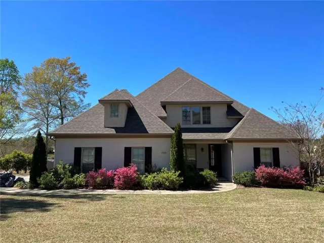 This charming home offers curb appeal with its traditional facade and neatly manicured landscaping.
