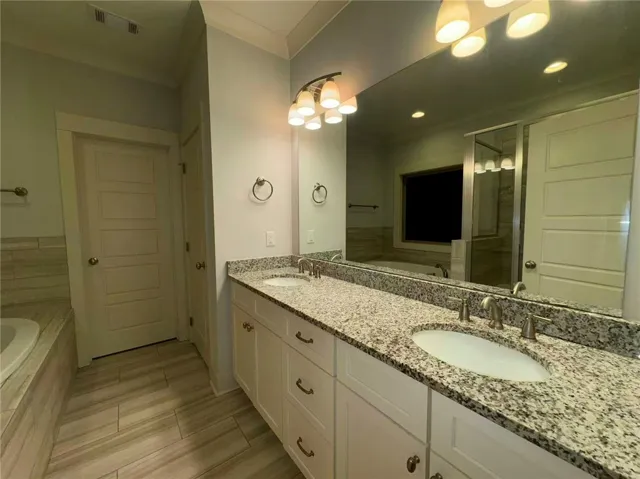 This bathroom features a double vanity and soaking tub, offering a relaxing retreat.