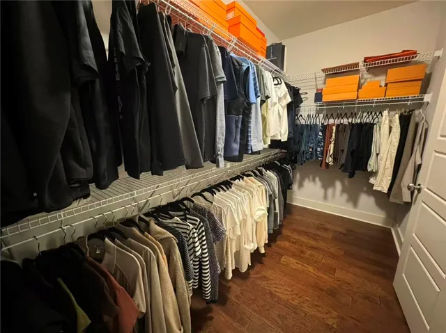This spacious closet offers ample storage and beautiful hardwood floors.