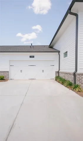 This residence showcases a clean facade with an attached garage and a concrete driveway.