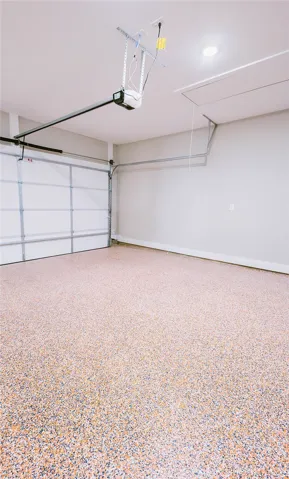 This spacious garage offers ample storage and features a durable, speckled floor.