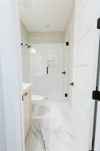 This bright bathroom features a spacious shower and sleek vanity.