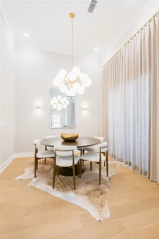 This bright dining area features an elegant light fixture, creating a warm and inviting atmosphere.