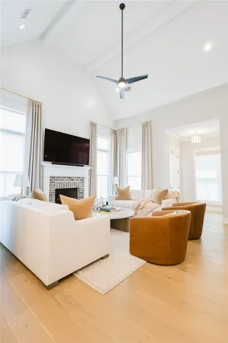 This airy living space features a captivating fireplace and abundant natural light.