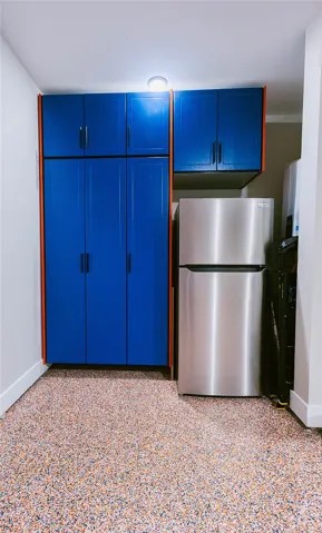 This organized space features practical cabinetry and a modern refrigerator.