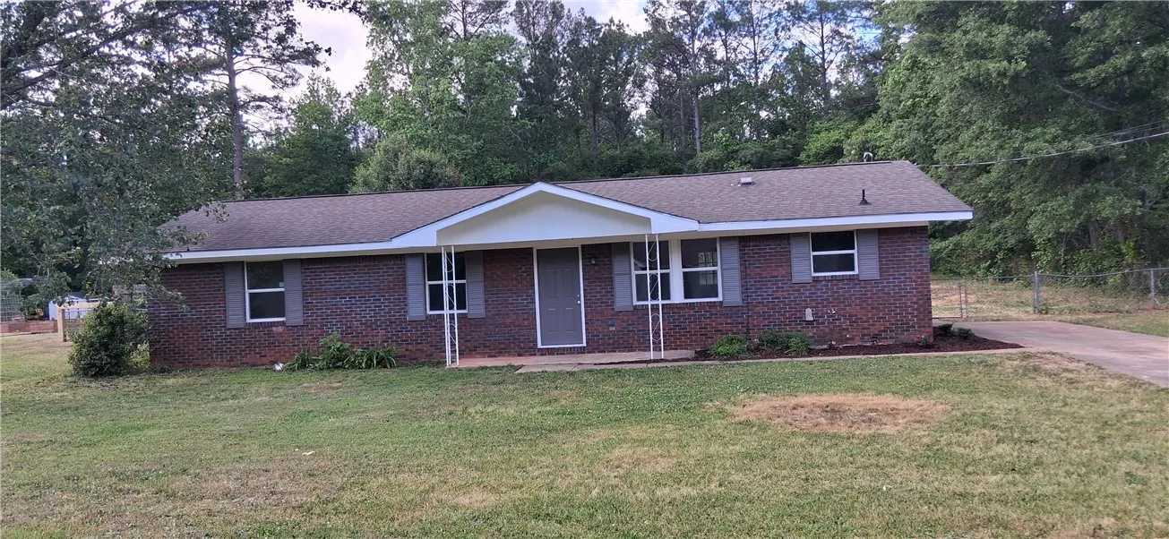 This classic brick residence offers a welcoming facade with traditional shutters and an inviting front porch.