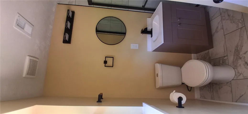 This bathroom features sleek tile flooring and modern fixtures, creating a clean and refreshing atmosphere.