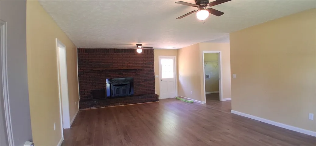 This living area features a classic brick fireplace and durable wood flooring.
