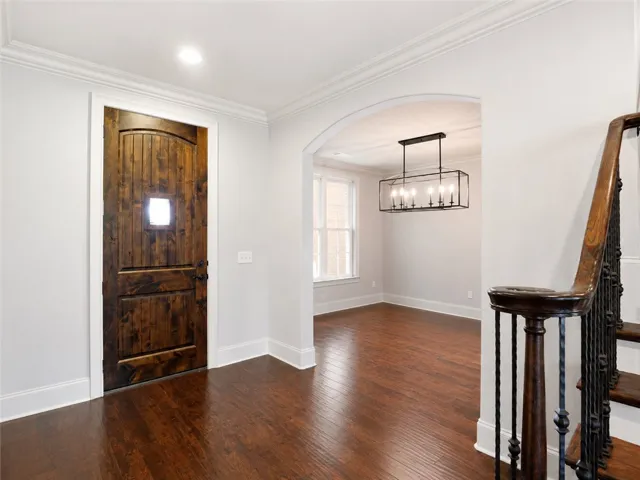 Rich hardwood floors welcome guests into this elegant entryway, leading to a spacious dining area.