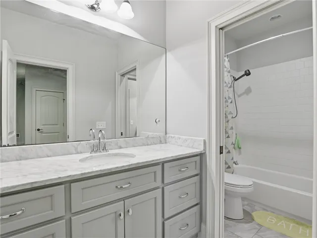 A well-lit bathroom features a large vanity with ample storage and a sparkling shower-tub combination.