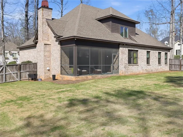 A private, fenced backyard offers an inviting screened-in porch, perfect for outdoor enjoyment.