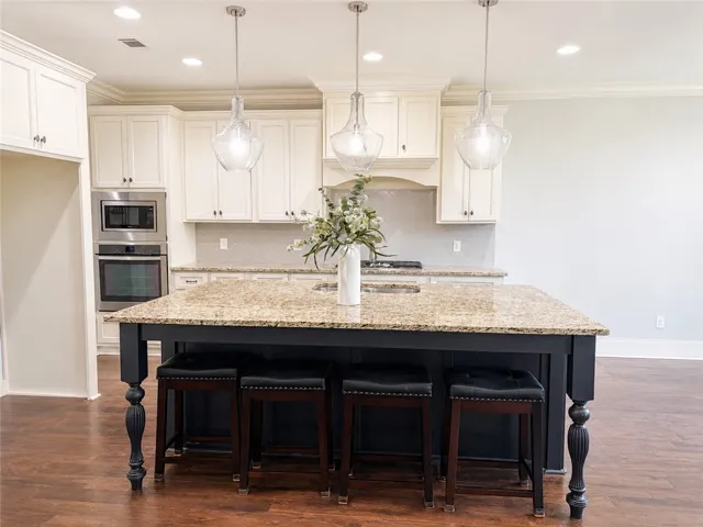 A chef's kitchen showcasing a large island with seating, ideal for culinary creations and entertaining.