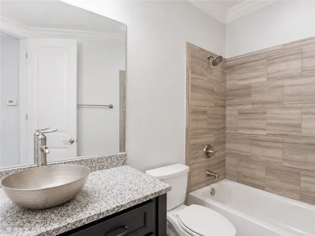 Modern bathroom featuring a stylish vessel sink and contemporary tiled shower surround.