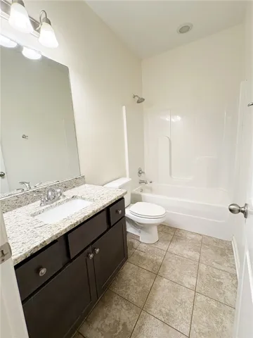 This clean and bright bathroom located on the first floor, features a vanity with ample storage and a shower-tub combination.
