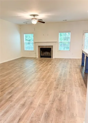 This living room offers generous space, a cozy wood burning fireplace, and abundant natural light.